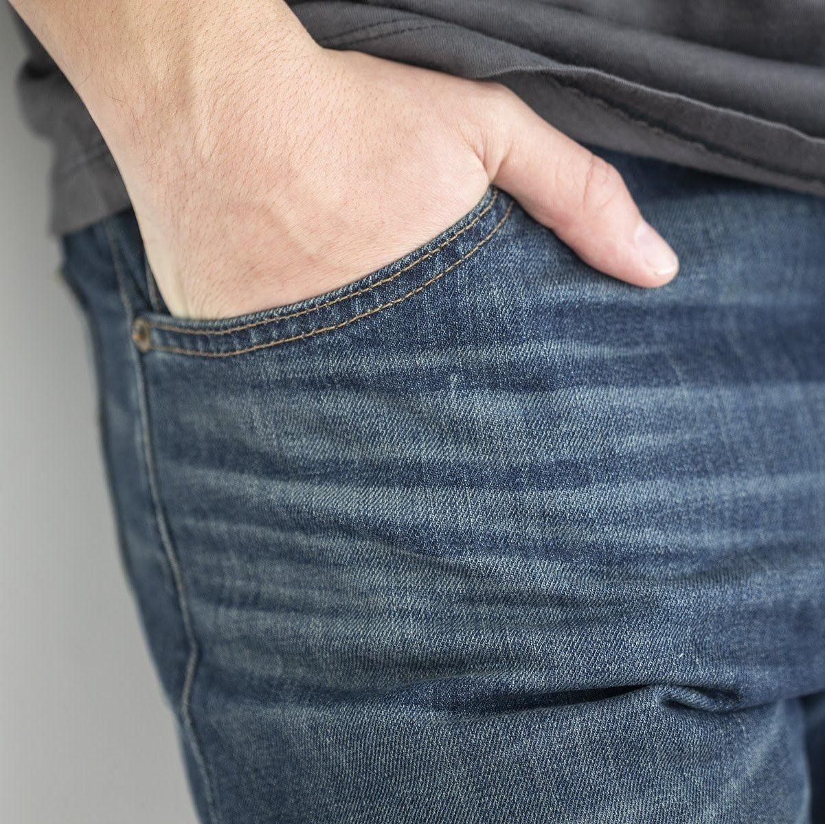 angle: 319 Wash | A model wears Raleigh Denim Workshop Alexander work fit jeans in the 319 wash, front view