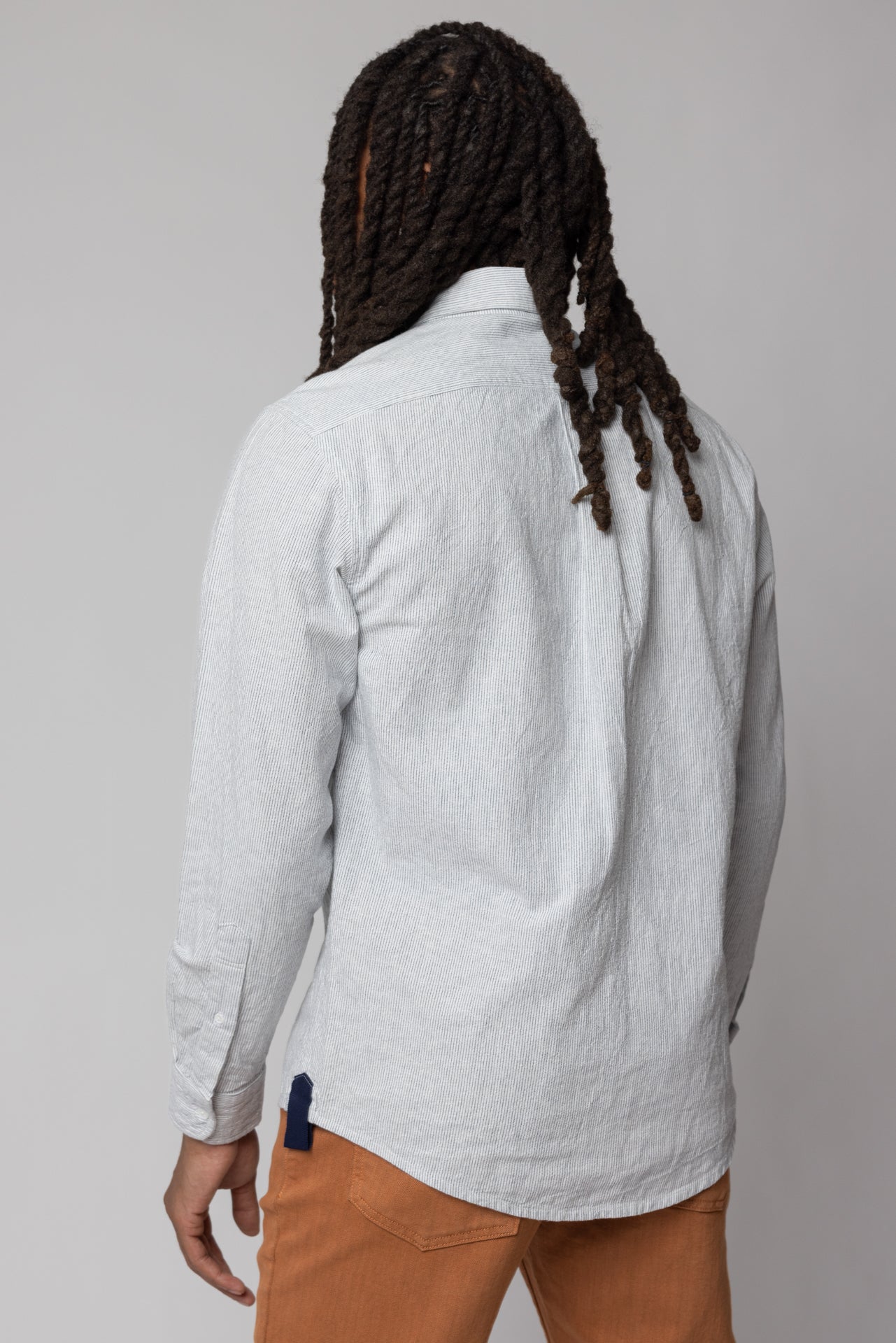 angle: Oxford Ticking Stripe: Man wears white oxford buttonup in ticking stripe