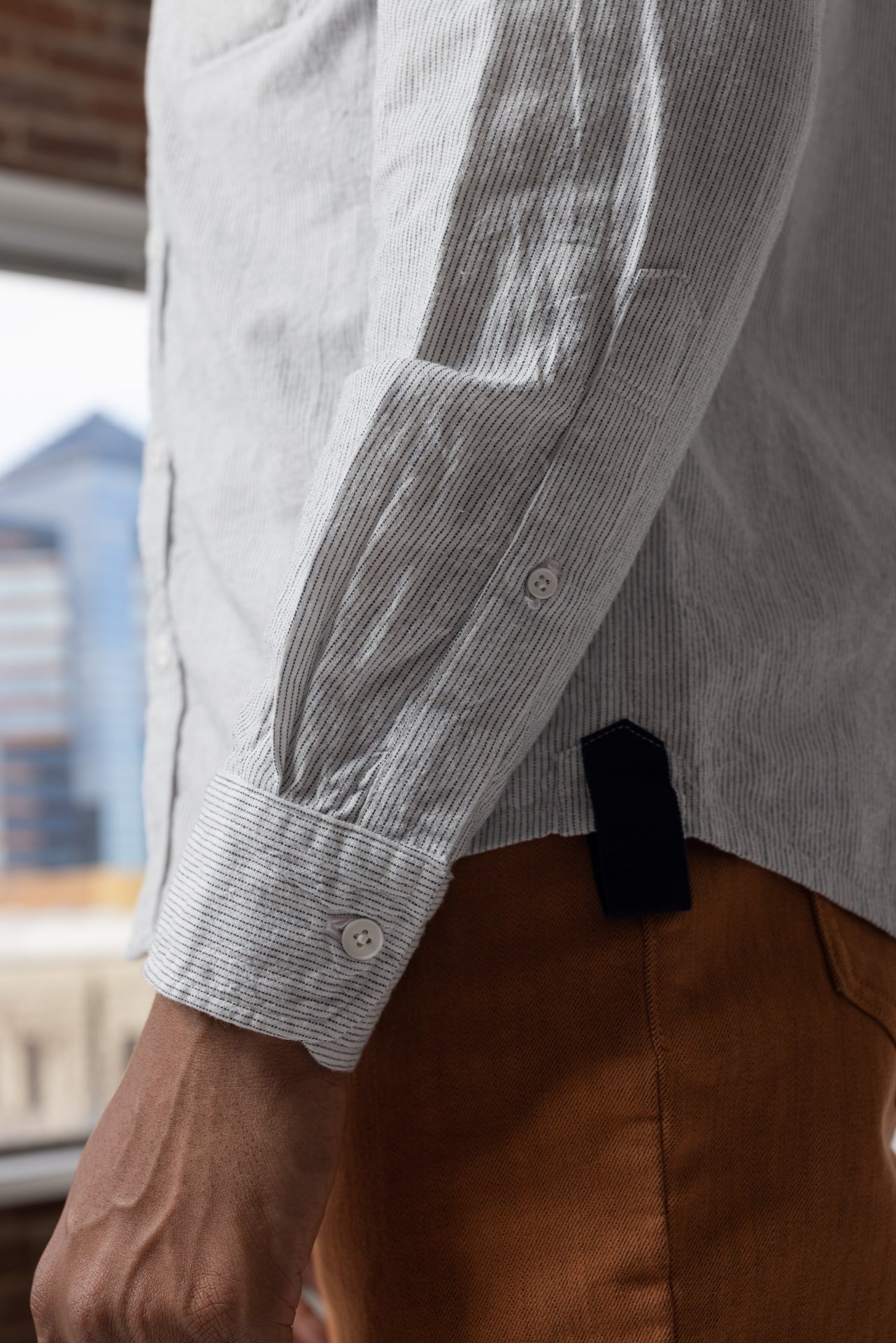 angle: Oxford Ticking Stripe: Man wears white oxford buttonup in ticking stripe