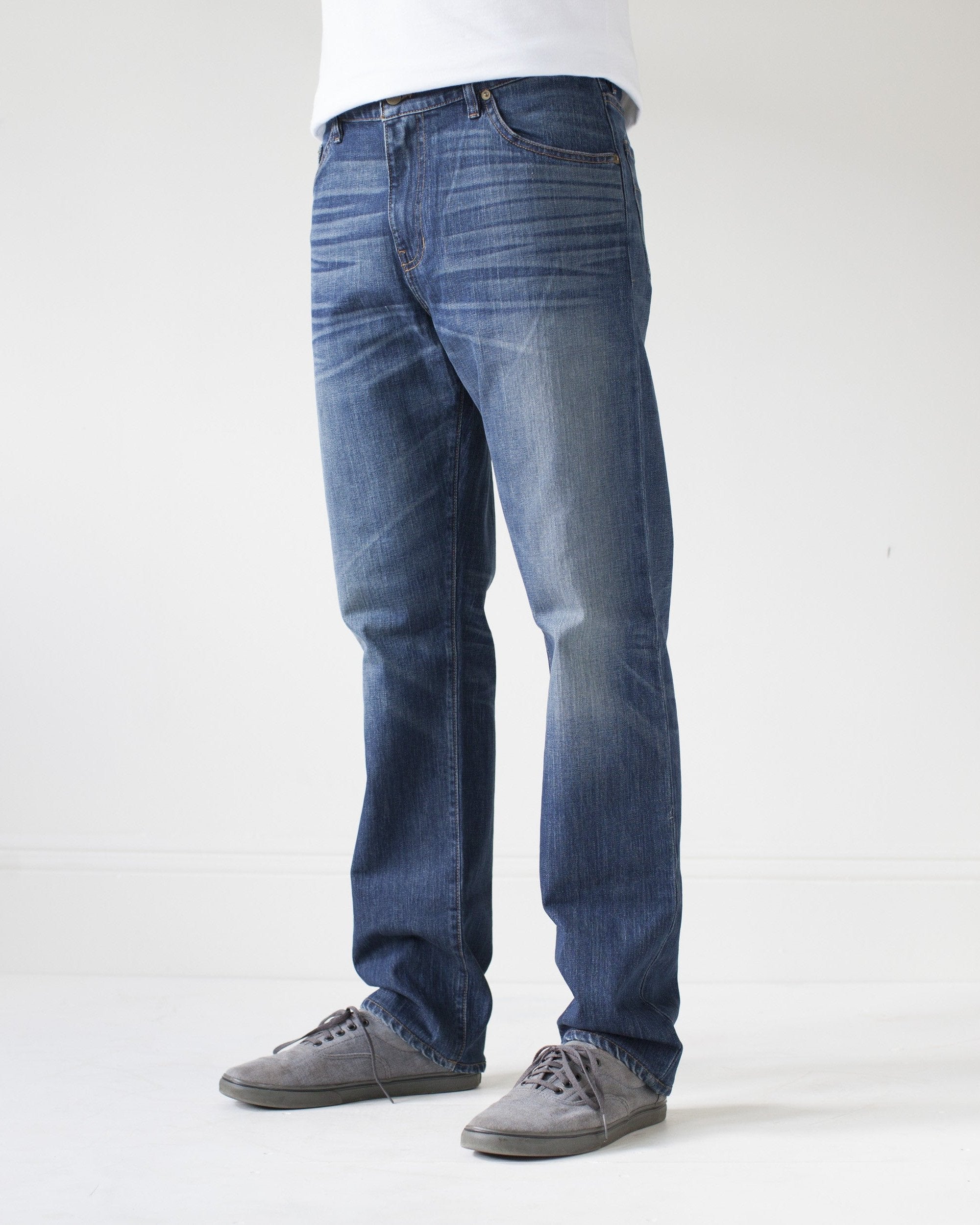 angle: 319 | A model wears Raleigh Denim Workshop Alexander work fit jeans in the 319 wash, side view