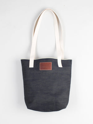 angle: denim | Raleigh Denim Workshop denim tote bag with cream handles and leather patch